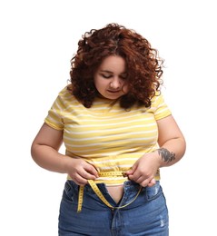 Photo of Weight loss. Plus size woman measuring waist with tape on white background