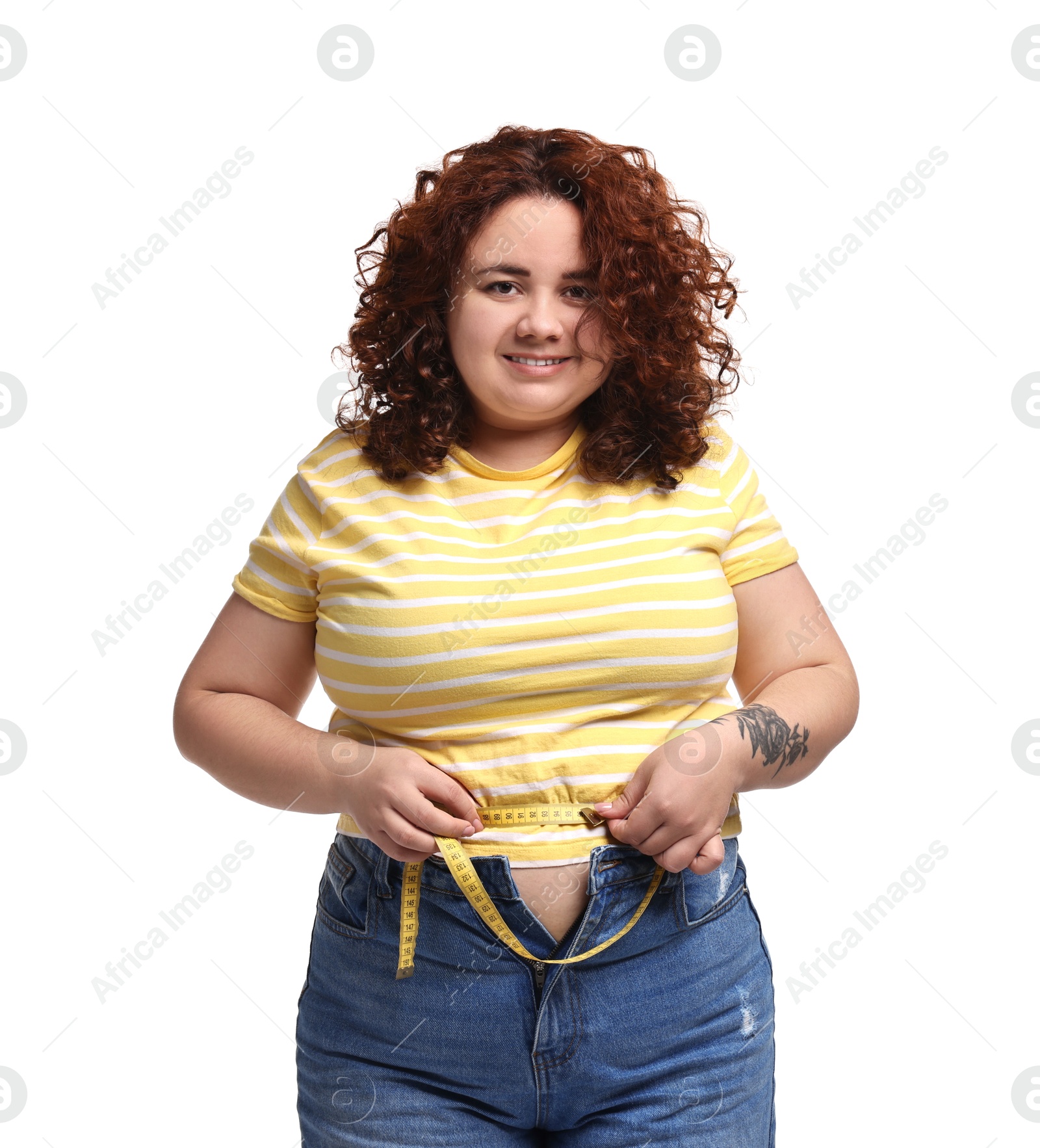 Photo of Weight loss. Happy plus size woman measuring waist with tape on white background