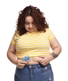 Photo of Plus size woman with blister of weight loss supplements on white background