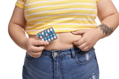 Photo of Plus size woman with blister of weight loss supplements on white background, closeup