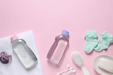 Photo of Baby oil and bath accessories on light pink background, flat lay. Space for text