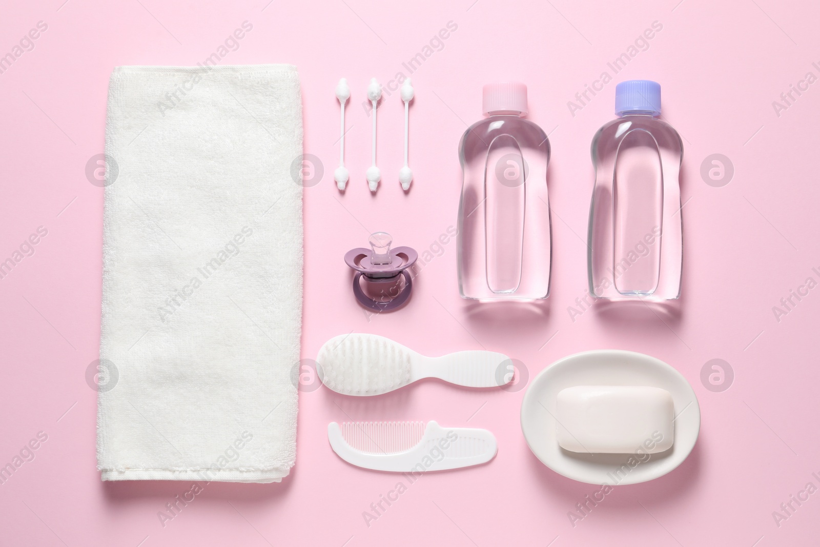 Photo of Baby oil and bath accessories on light pink background, flat lay