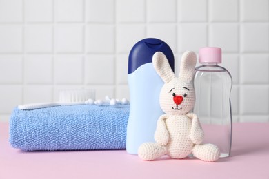 Photo of Baby oil and bath accessories on pink table