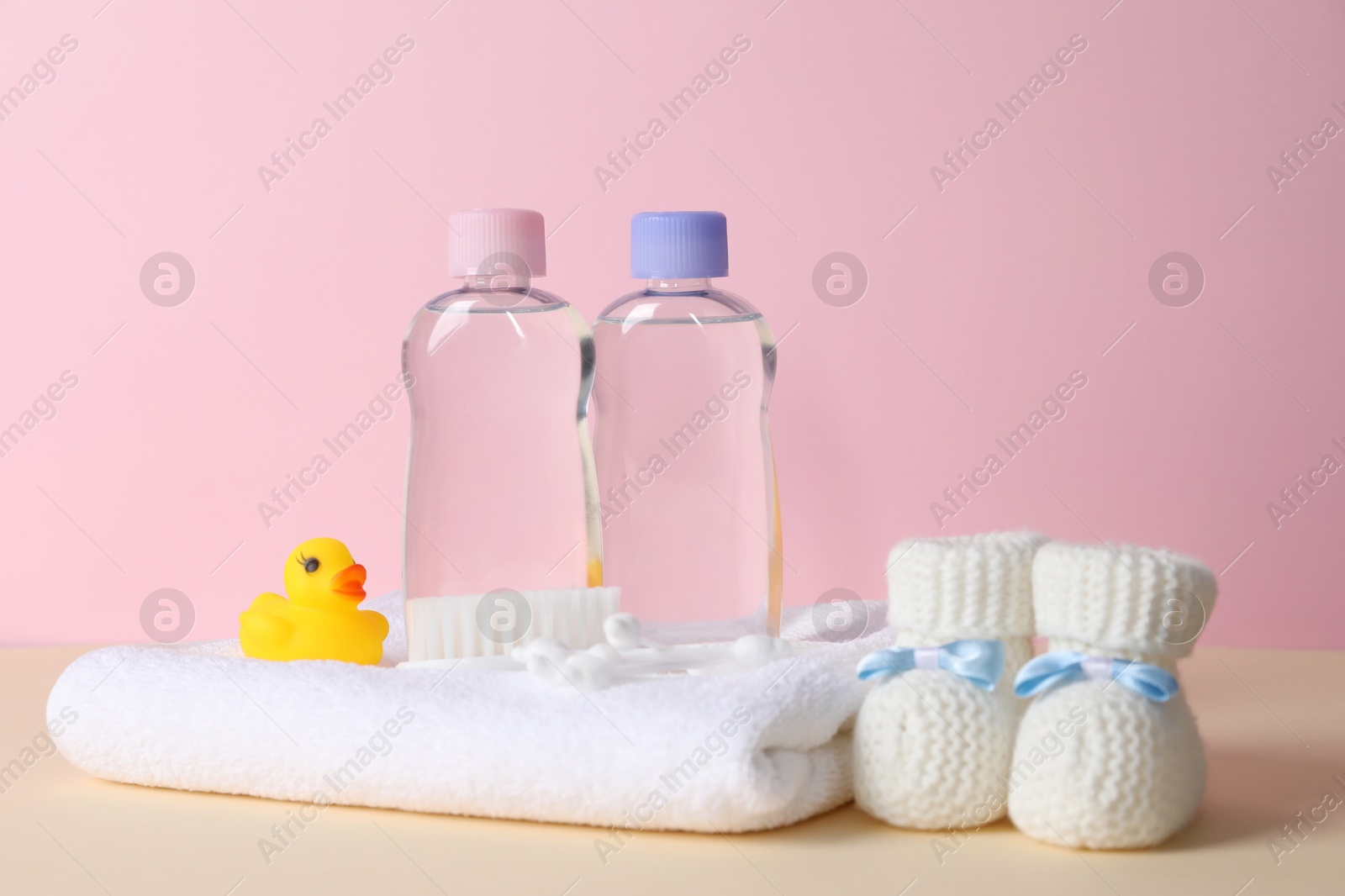 Photo of Baby oil and bath accessories on color background