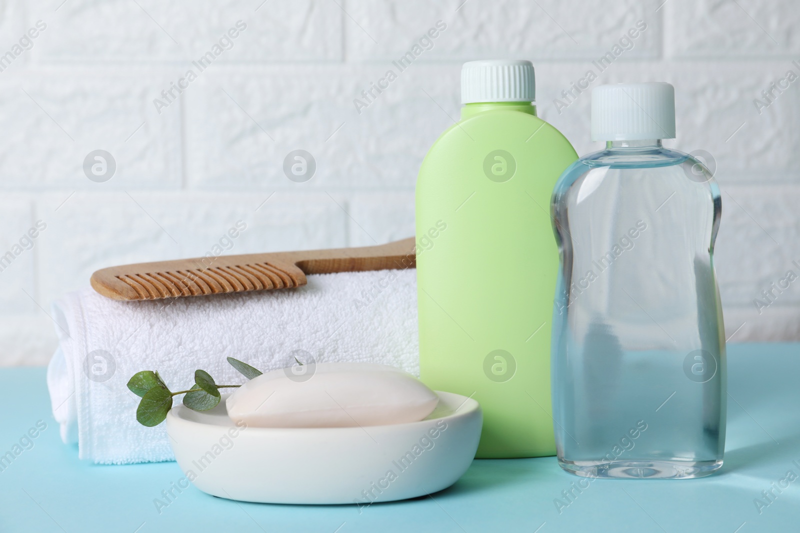 Photo of Baby oil and bath accessories on blue table