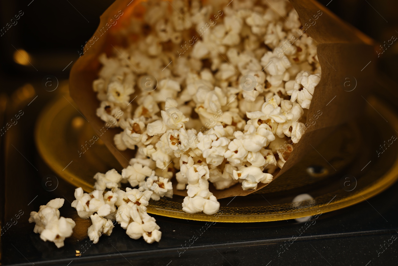 Photo of Bag of tasty popcorn in microwave oven, closeup