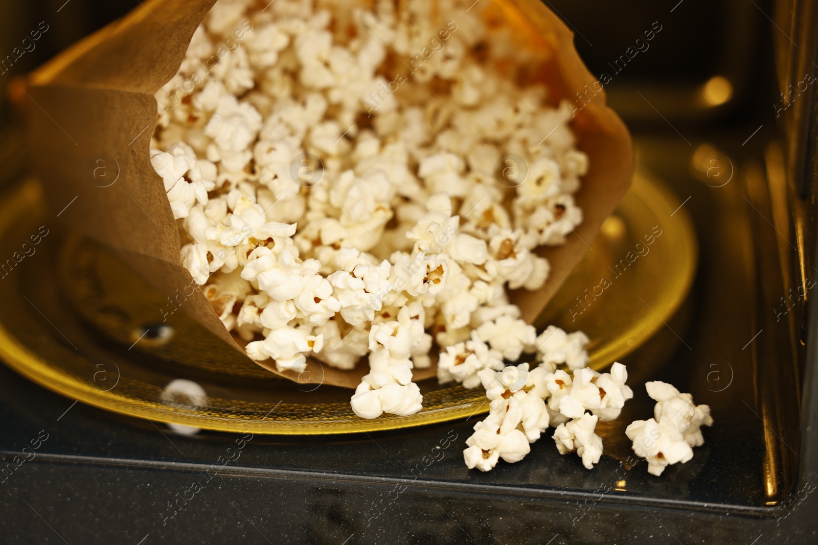 Photo of Bag of tasty popcorn in microwave oven, closeup