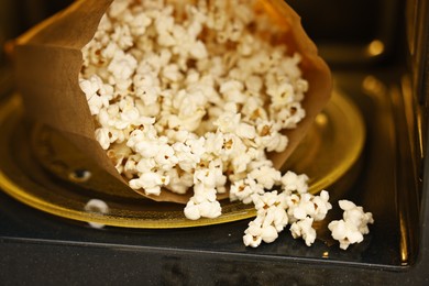 Photo of Bag of tasty popcorn in microwave oven, closeup