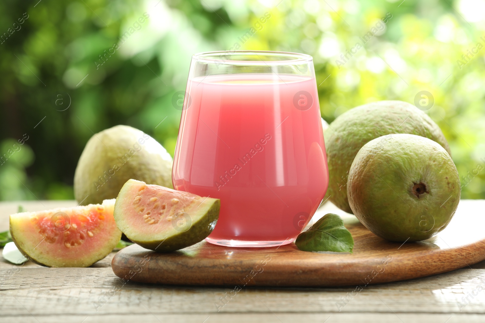 Photo of Refreshing guava juice and fresh fruits on wooden table, closeup