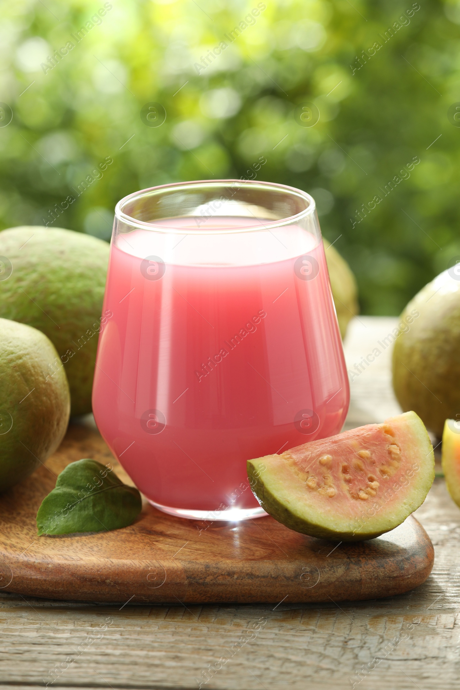 Photo of Refreshing guava juice and fresh fruits on wooden table, closeup