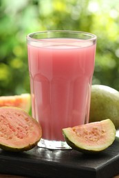 Photo of Refreshing guava juice and fresh fruits on wooden table, closeup