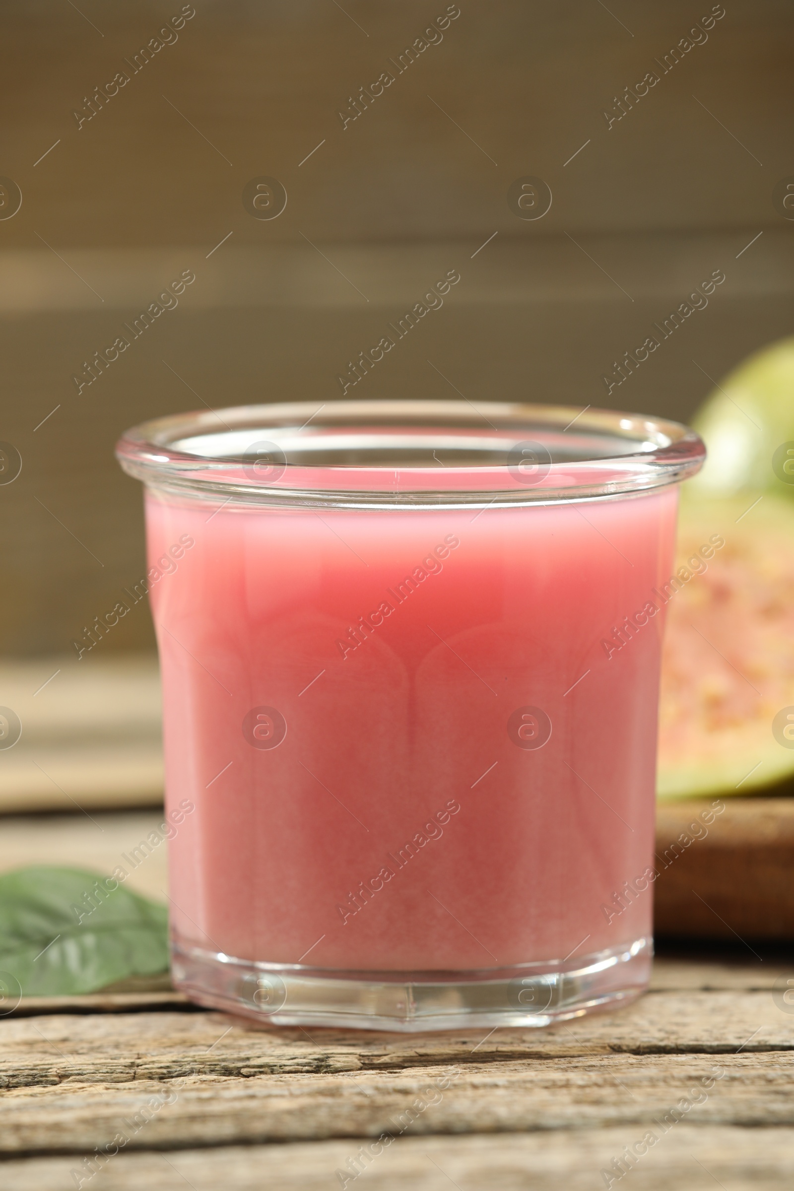 Photo of Refreshing guava juice and fresh fruits on wooden table, closeup