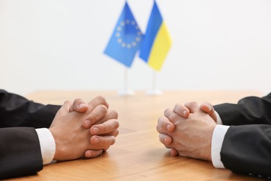 Diplomats negotiating during meeting at wooden table indoors, closeup