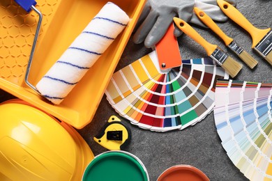 Photo of Flat lay composition with different painter's tools on grey table. Decorating and design