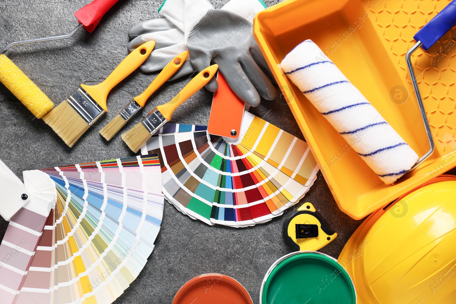 Photo of Flat lay composition with different painter's tools on grey table. Decorating and design