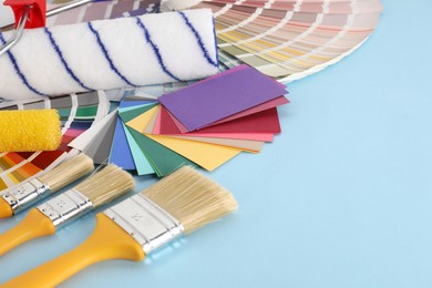 Photo of Different painter's tools on light blue table, space for text. Decorating and design