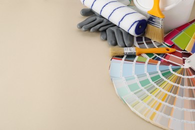 Photo of Different painter's tools on beige table, space for text. Decorating and design