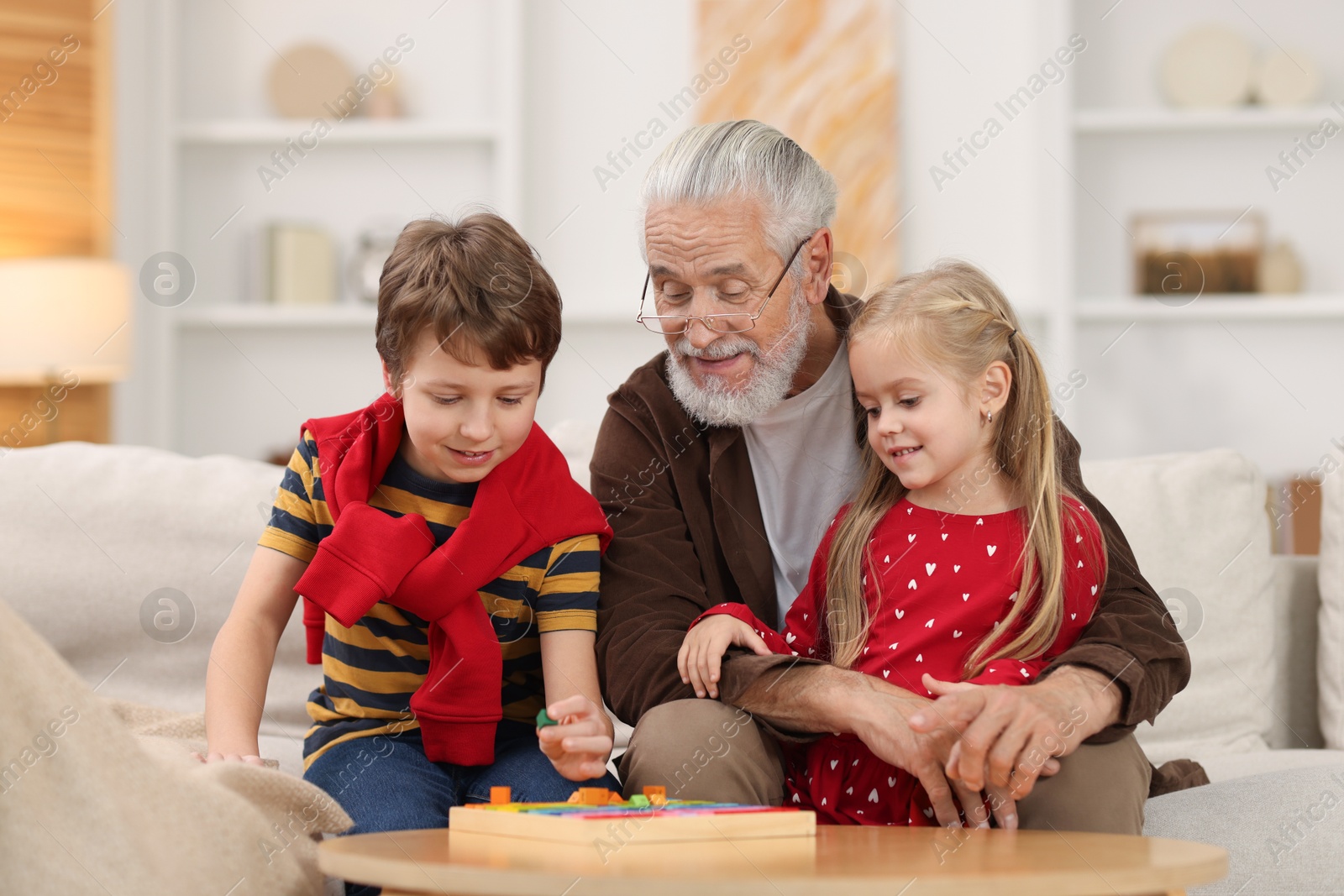 Photo of Grandpa and his grandkids playing with math game Times table tray at home