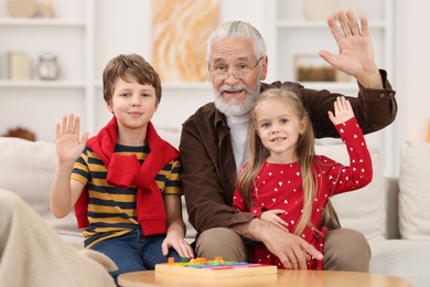 Photo of Portrait of grandpa and his grandkids at home