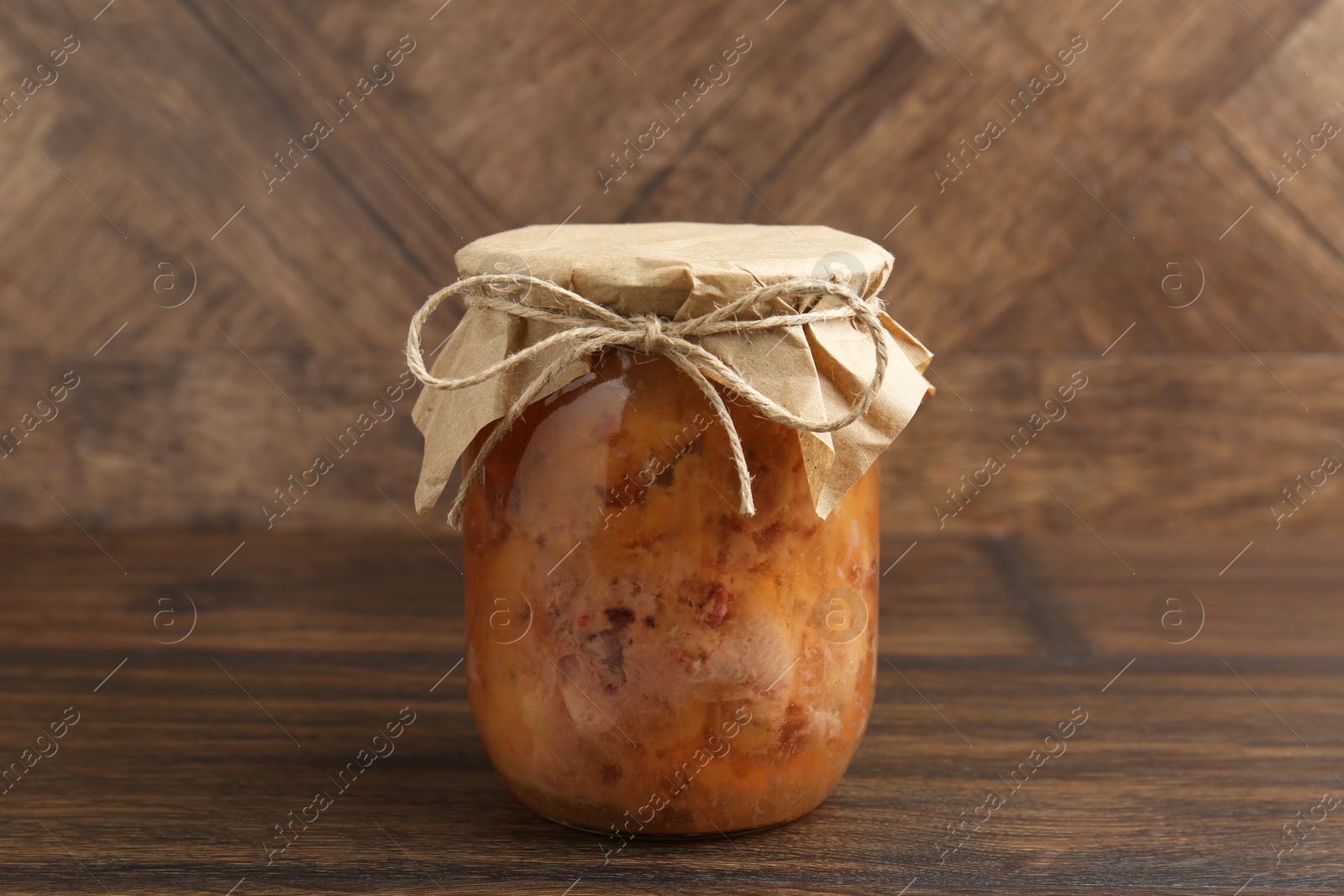 Photo of Canned meat in glass jar on wooden table