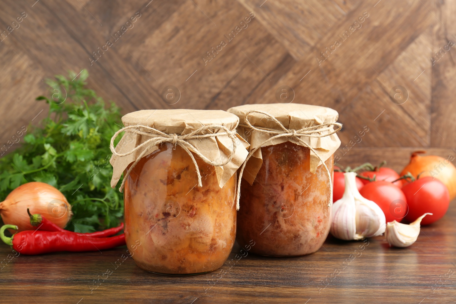 Photo of Canned meat in glass jars and other products on wooden table