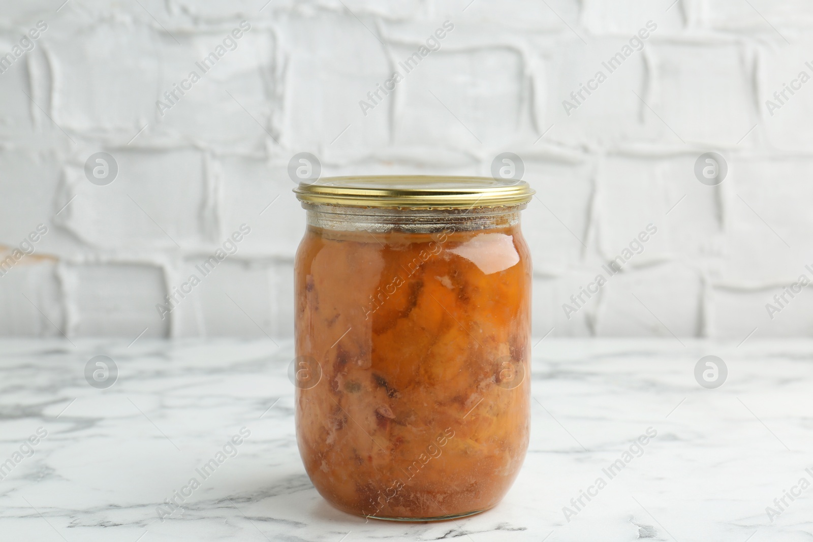 Photo of Canned meat in glass jar on white marble table