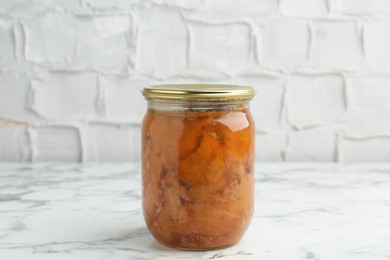 Photo of Canned meat in glass jar on white marble table