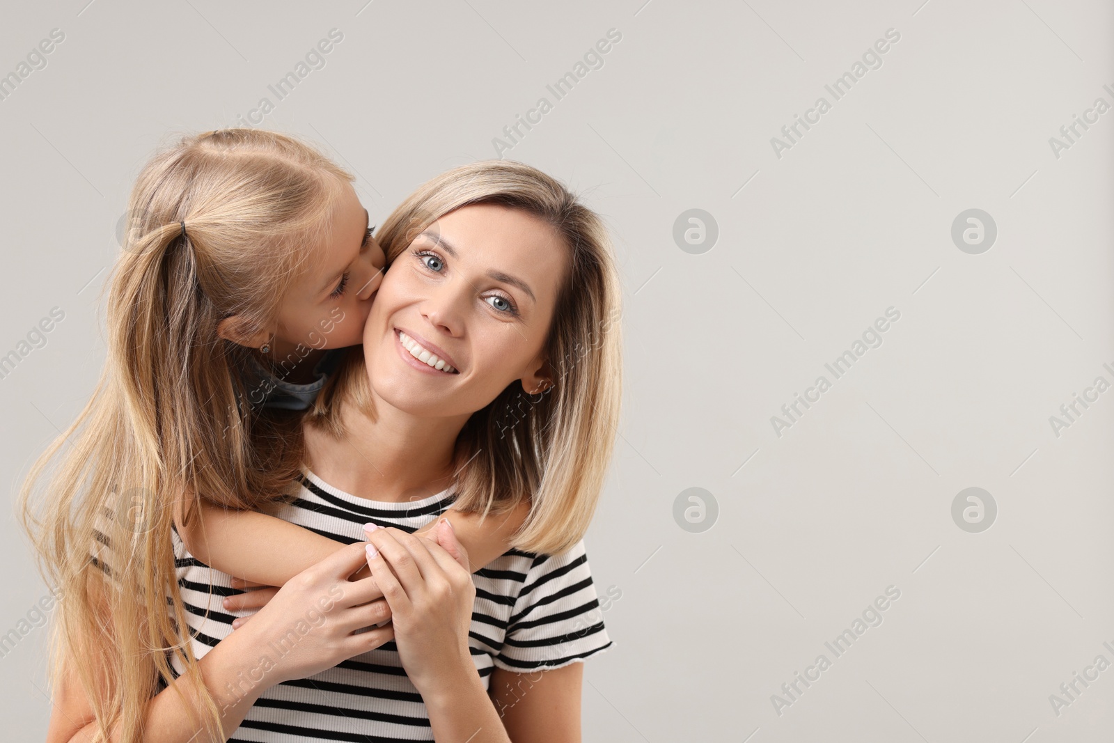 Photo of Cute little girl with her mom on gray background, space for text. Happy Mother's Day