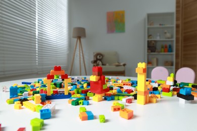 Photo of Construction toy. Figures made with building bricks and colorful blocks on white table indoors