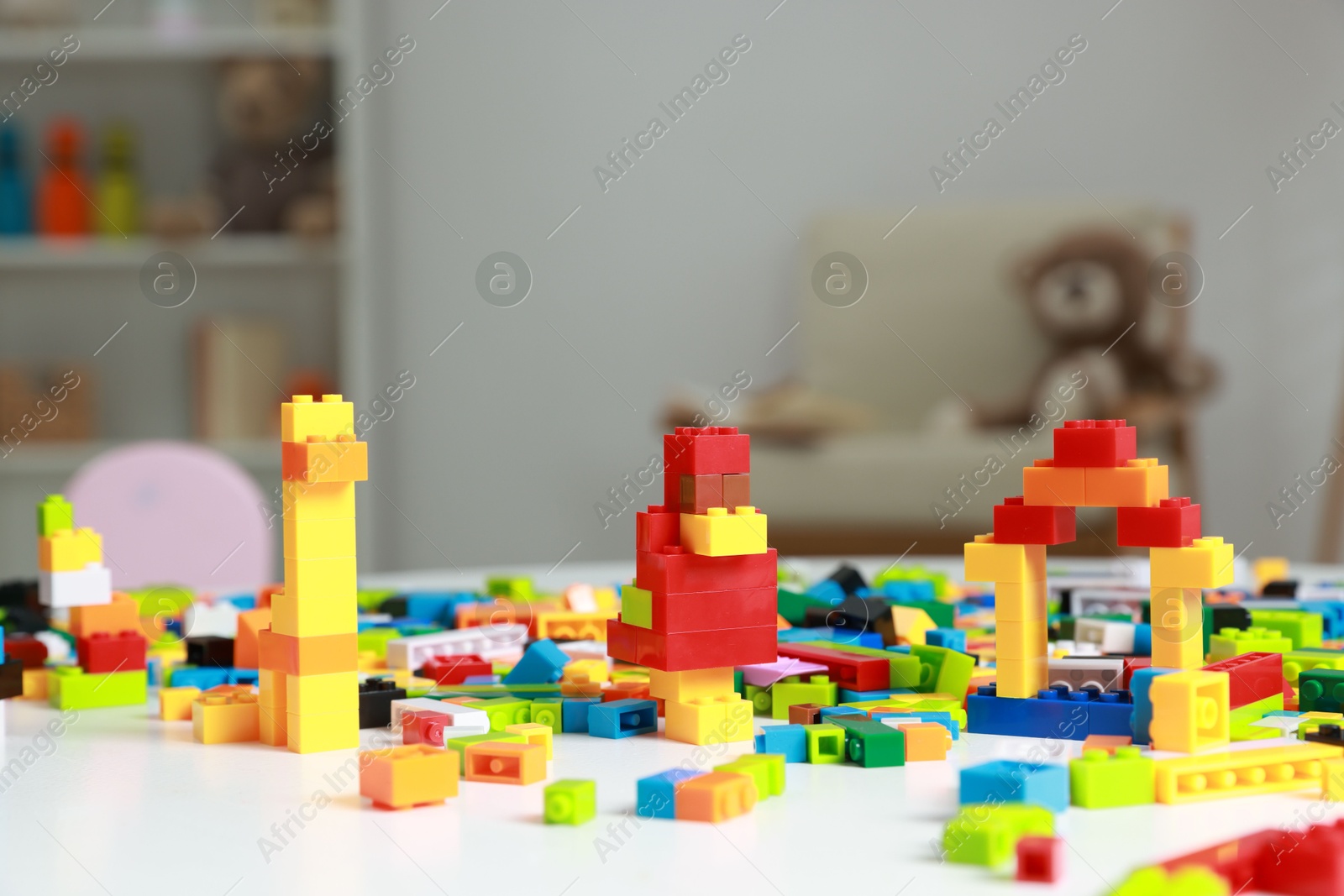 Photo of Construction toy. Colorful building blocks on white table indoors, closeup