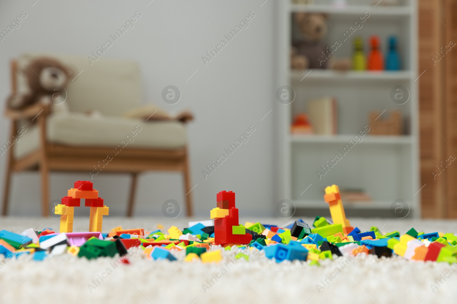 Photo of Construction toy. Figures made with building bricks and colorful blocks on floor indoors