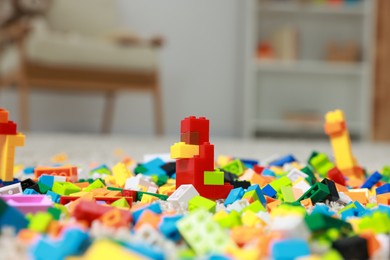 Photo of Construction toy. Figure made with building bricks and colorful blocks on floor indoors, closeup