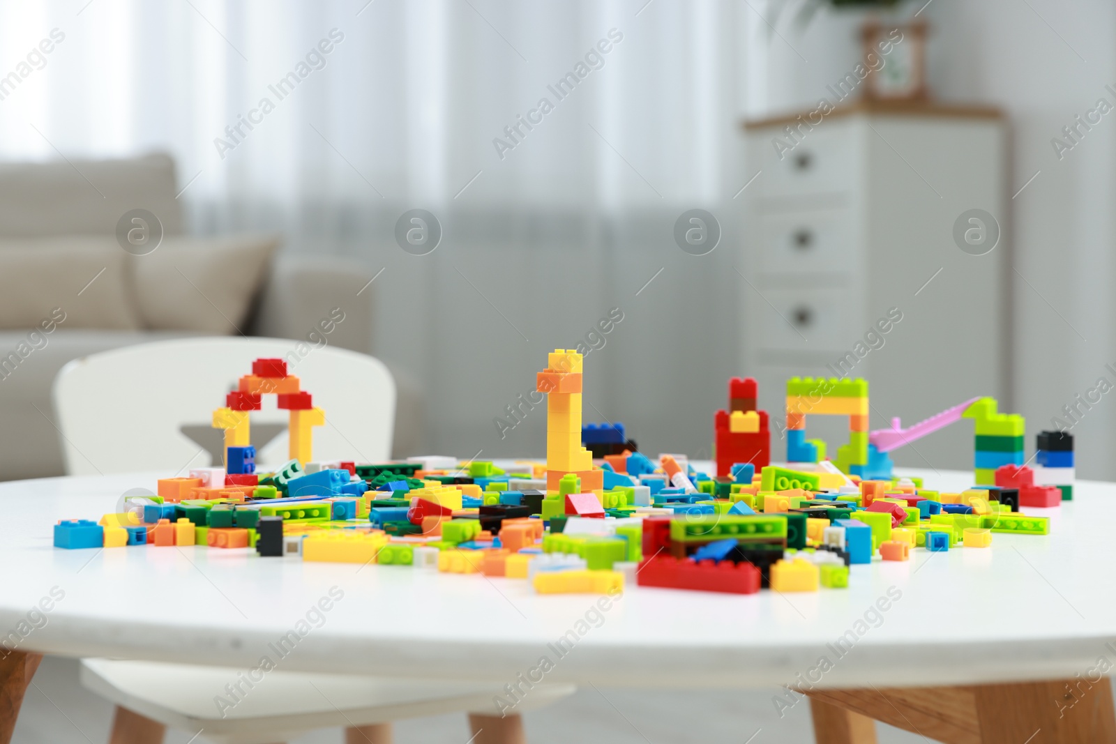 Photo of Construction toy. Figures made with building bricks and colorful blocks on white table indoors