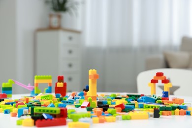 Photo of Construction toy. Figures made with building bricks and colorful blocks on table indoors