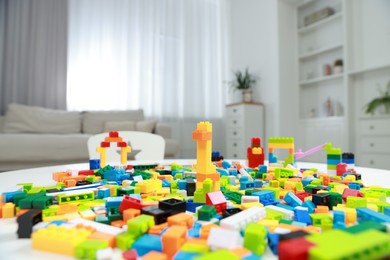 Photo of Construction toy. Figures made with building bricks and colorful blocks on table indoors