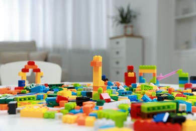 Photo of Construction toy. Figures made with building bricks and colorful blocks on table indoors