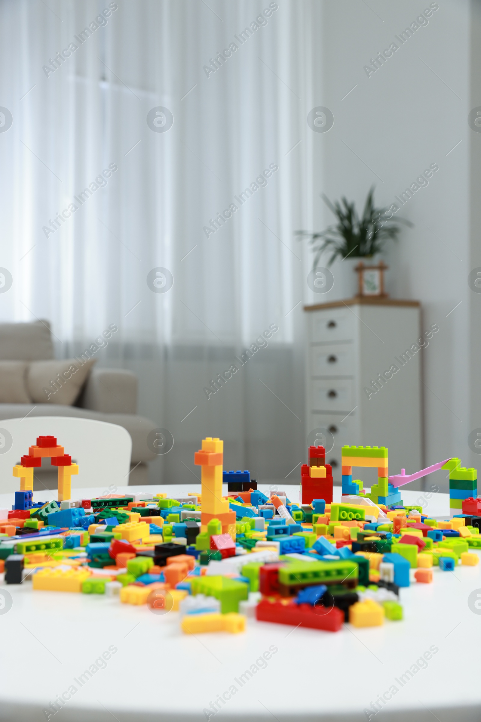 Photo of Construction toy. Figures made with building bricks and colorful blocks on white table indoors