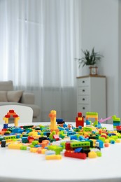 Photo of Construction toy. Figures made with building bricks and colorful blocks on white table indoors