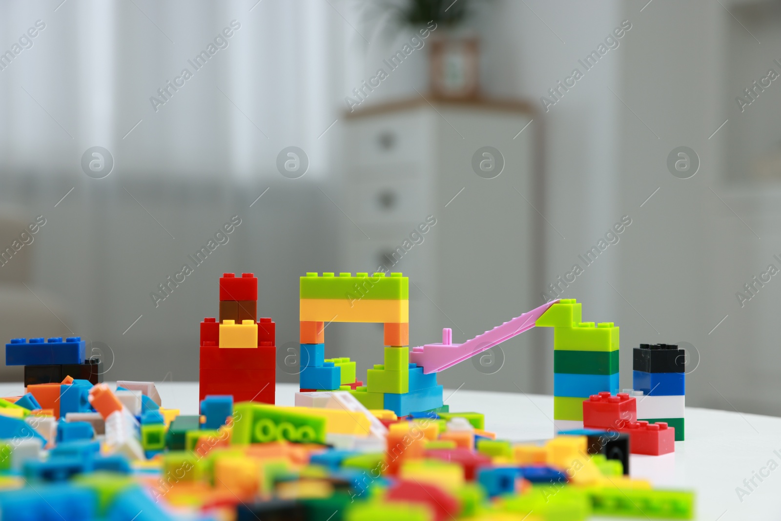 Photo of Construction toy. Figures made with building bricks and colorful blocks on table indoors