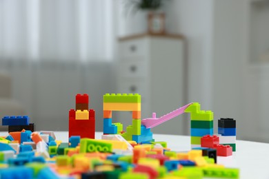 Photo of Construction toy. Figures made with building bricks and colorful blocks on table indoors