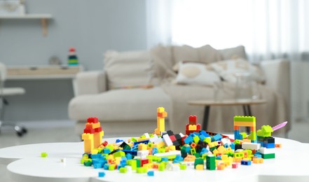 Photo of Construction toy. Figures made with building bricks and colorful blocks on white table indoors