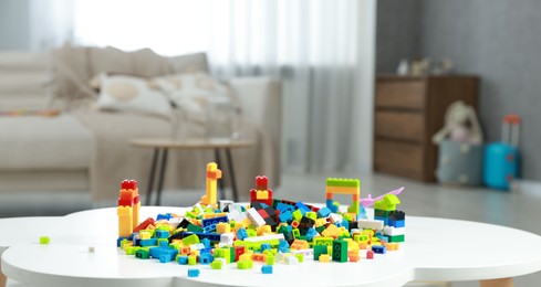 Photo of Construction toy. Figures made with building bricks and colorful blocks on white table indoors