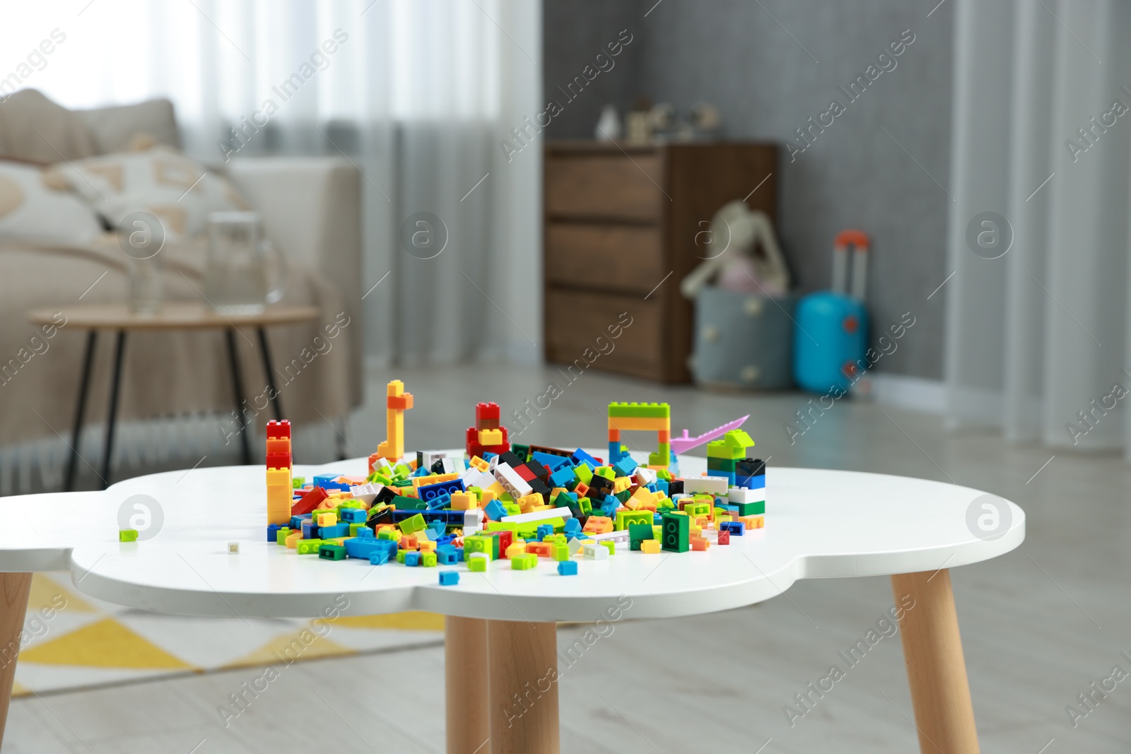 Photo of Construction toy. Figures made with building bricks and colorful blocks on white table indoors