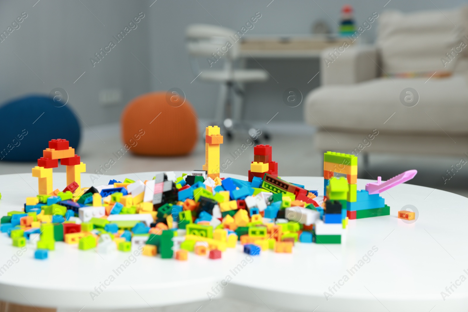 Photo of Construction toy. Figures made with building bricks and colorful blocks on white table indoors