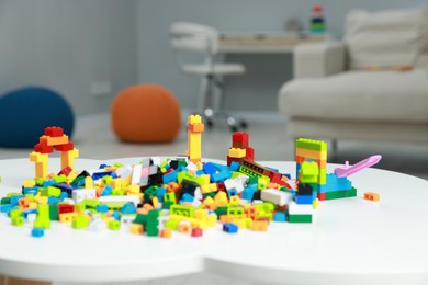 Photo of Construction toy. Figures made with building bricks and colorful blocks on white table indoors