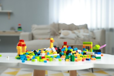 Photo of Construction toy. Figures made with building bricks and colorful blocks on white table indoors