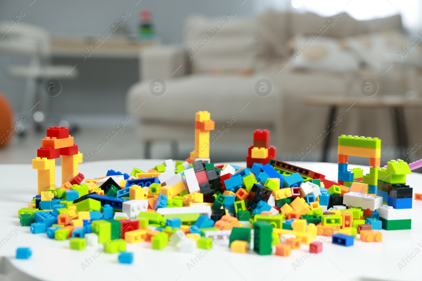 Photo of Construction toy. Figures made with building bricks and colorful blocks on white table indoors