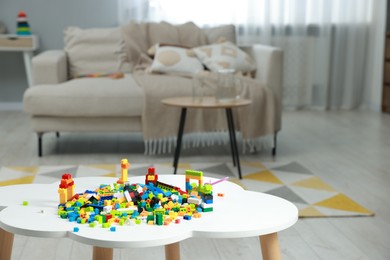 Photo of Construction toy. Figures made with building bricks and colorful blocks on white table indoors