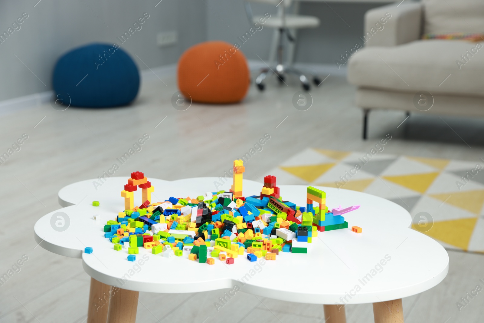 Photo of Construction toy. Figures made with building bricks and colorful blocks on white table indoors