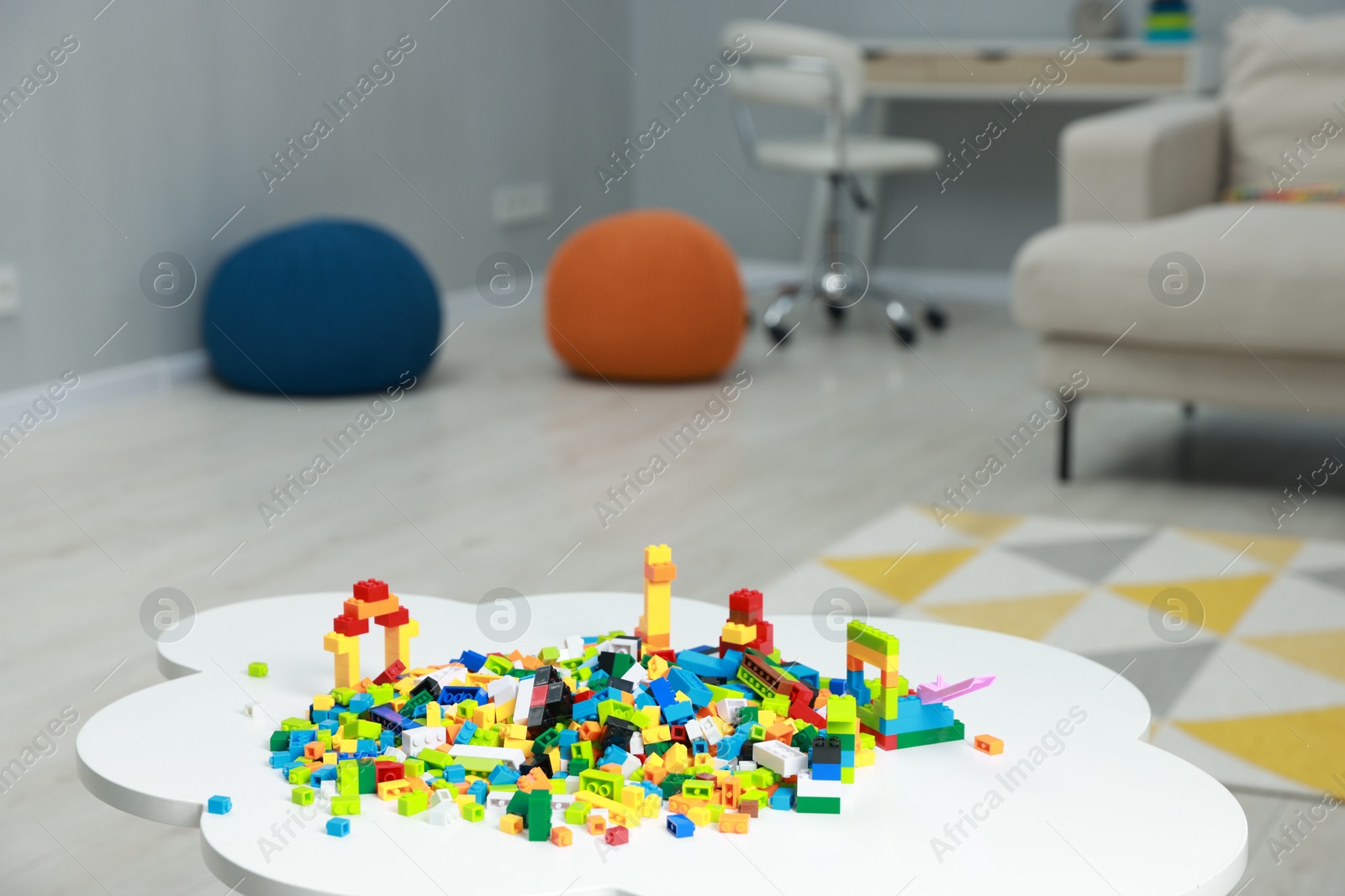 Photo of Construction toy. Figures made with building bricks and colorful blocks on white table indoors